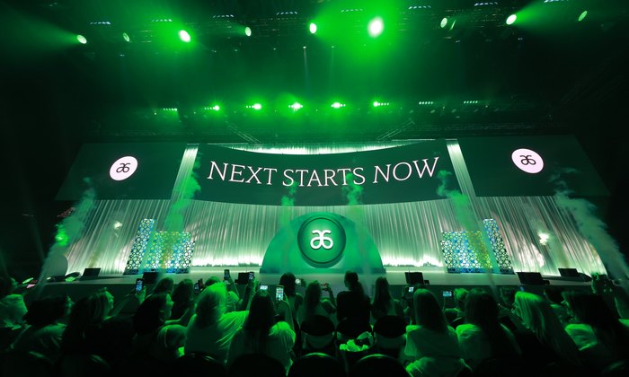 Audience viewing a green-lit main stage during a Bartha-produced event.